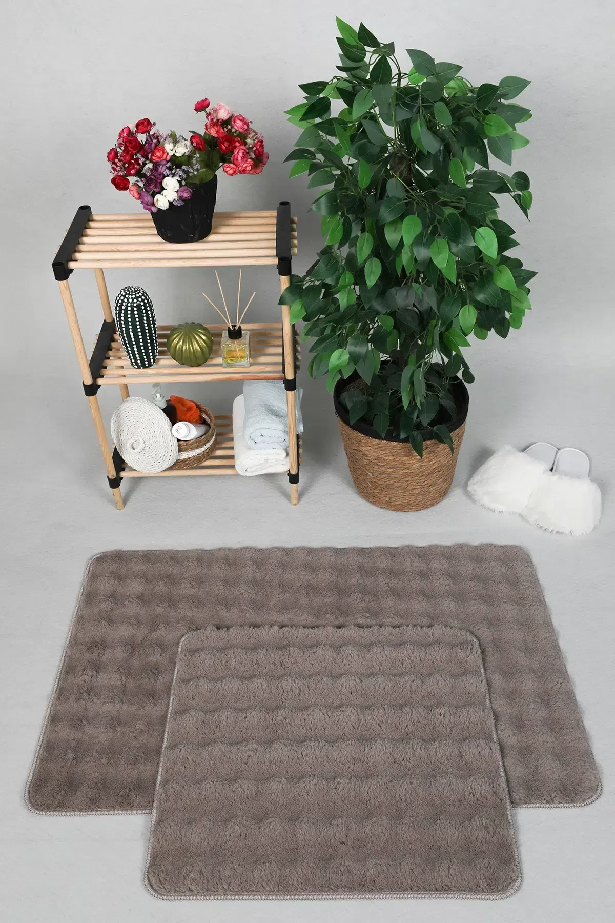 Havlu ve beyaz kürklü terliklerle birlikte kahverengi banyo paspası