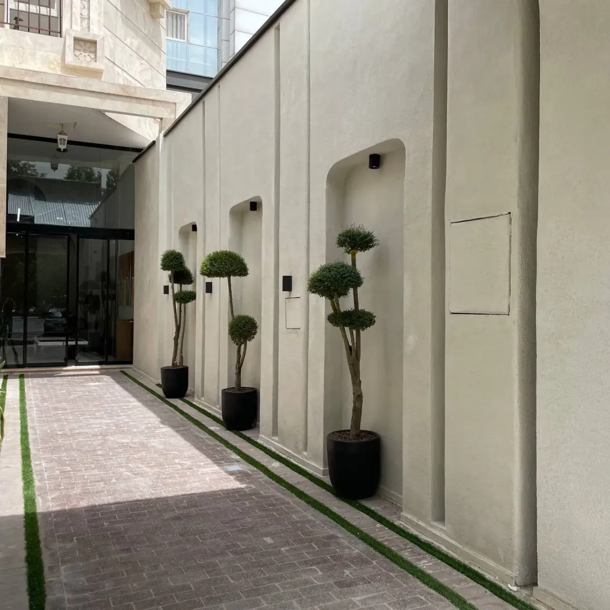 现代建筑入口，奶油色墙面与装饰花盆