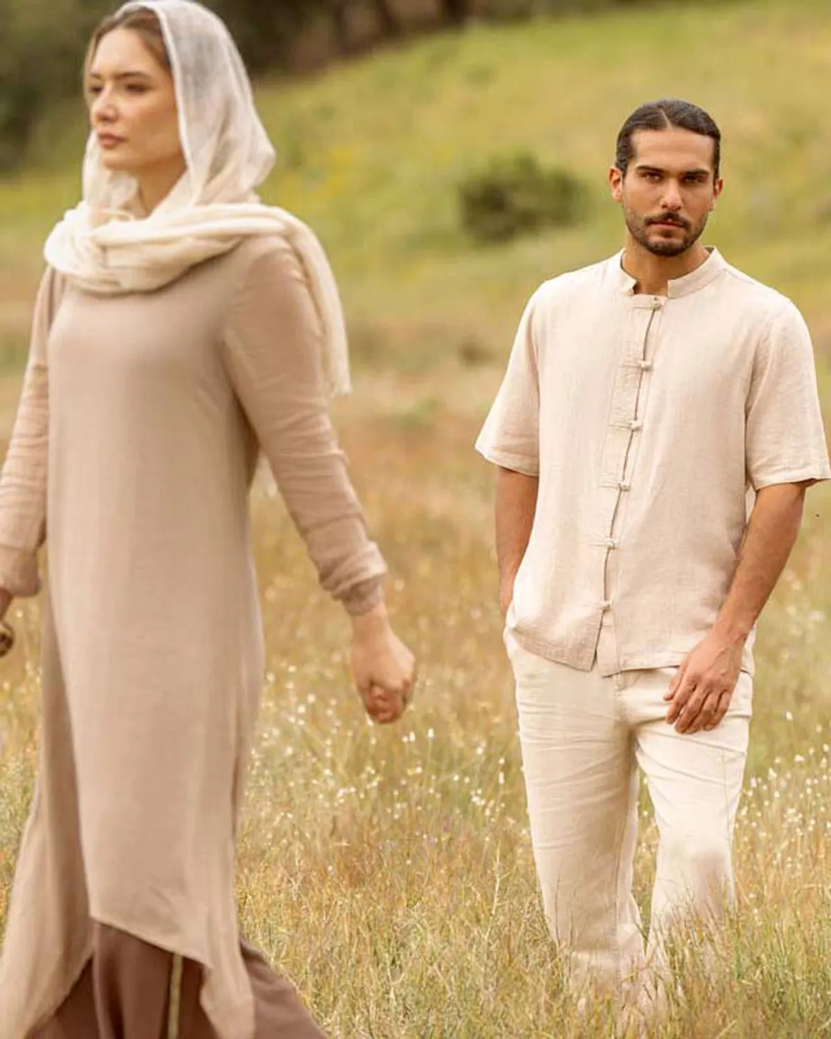 A man and a woman in a wheat field wearing Tandorost shirts and a coat, experiencing a sense of coolness and relief from the heat.