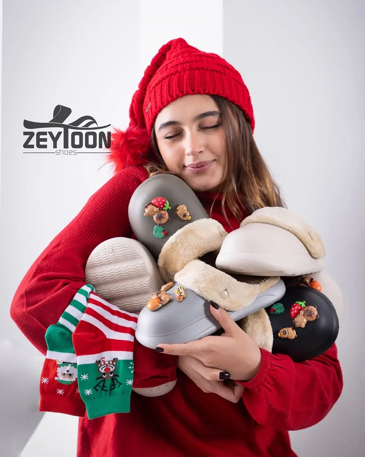 Bir kadın, peluş ve Noel terliklerini tutuyor ve onlara bakıyor.