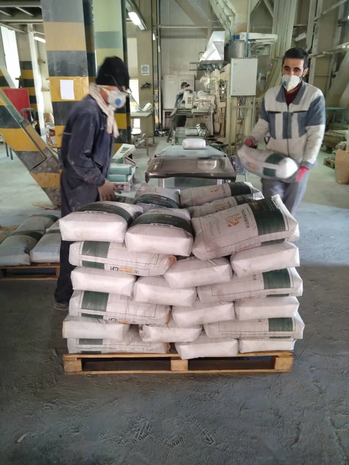 Процесс упаковки сухих строительных смесей Бунёд Бетон Исфахан на различных стадиях производства.